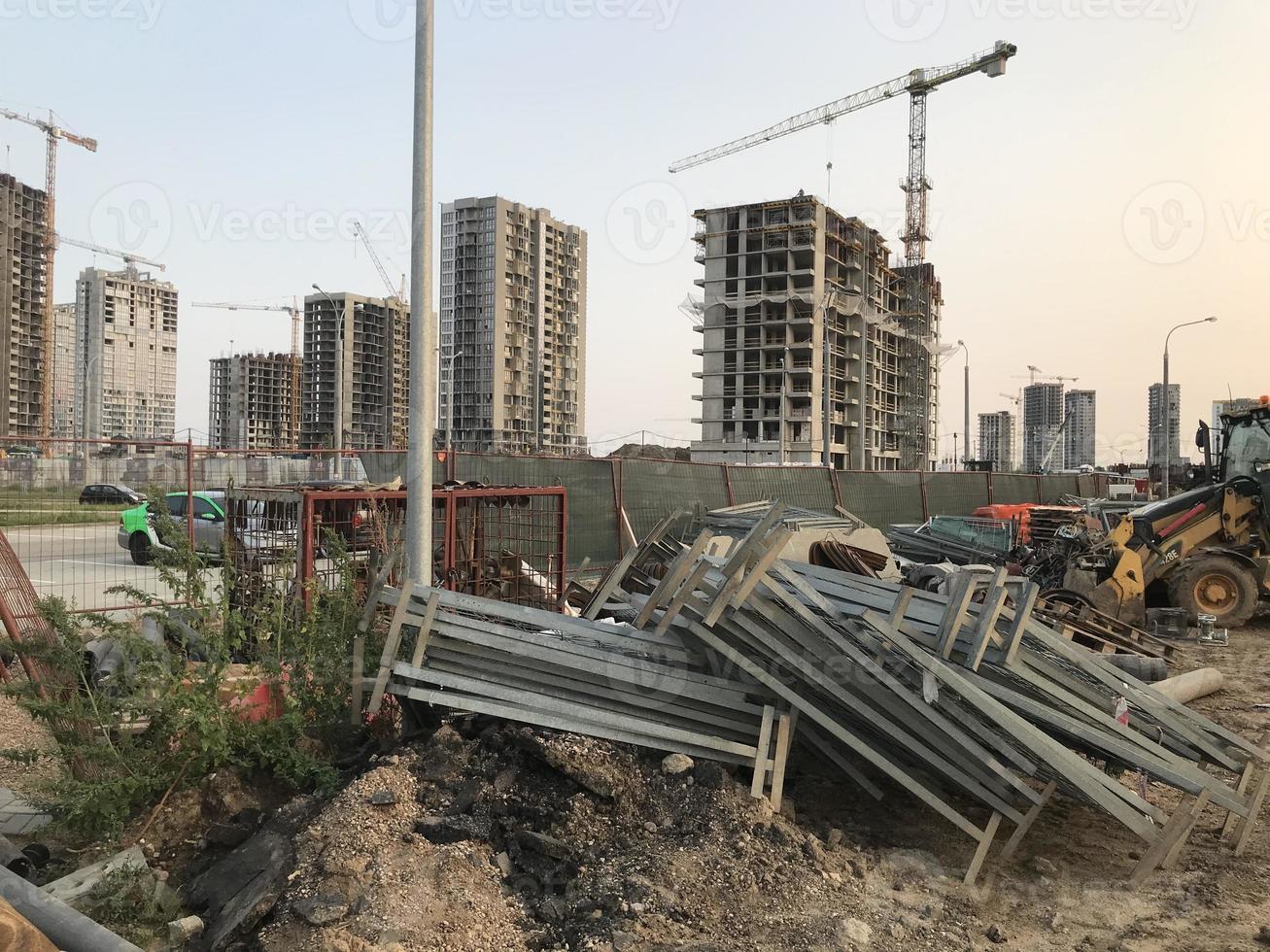 large wooden pallets lie against the backdrop of multi-storey buildings. construction of a new microdistrict in the city center. new house photo