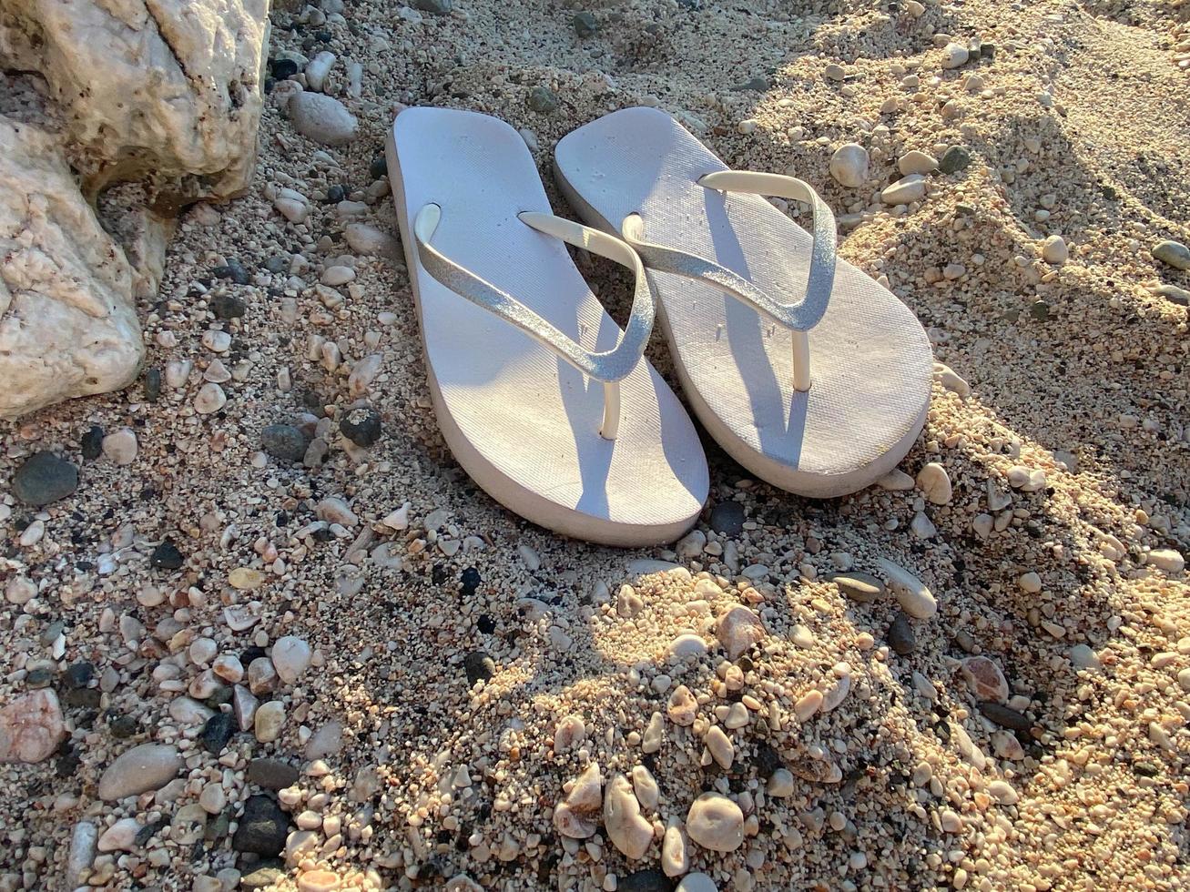 Summer background of beach and shoes on sand. Free space for your decoration photo