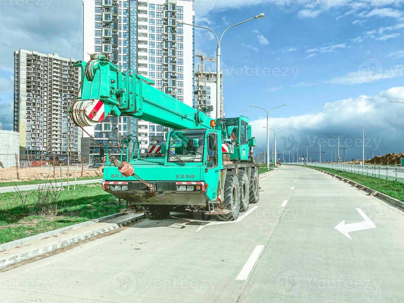 The boom-type crane moves without a load, without requiring special tracks. truck crane at the construction site of a new microdistrict photo