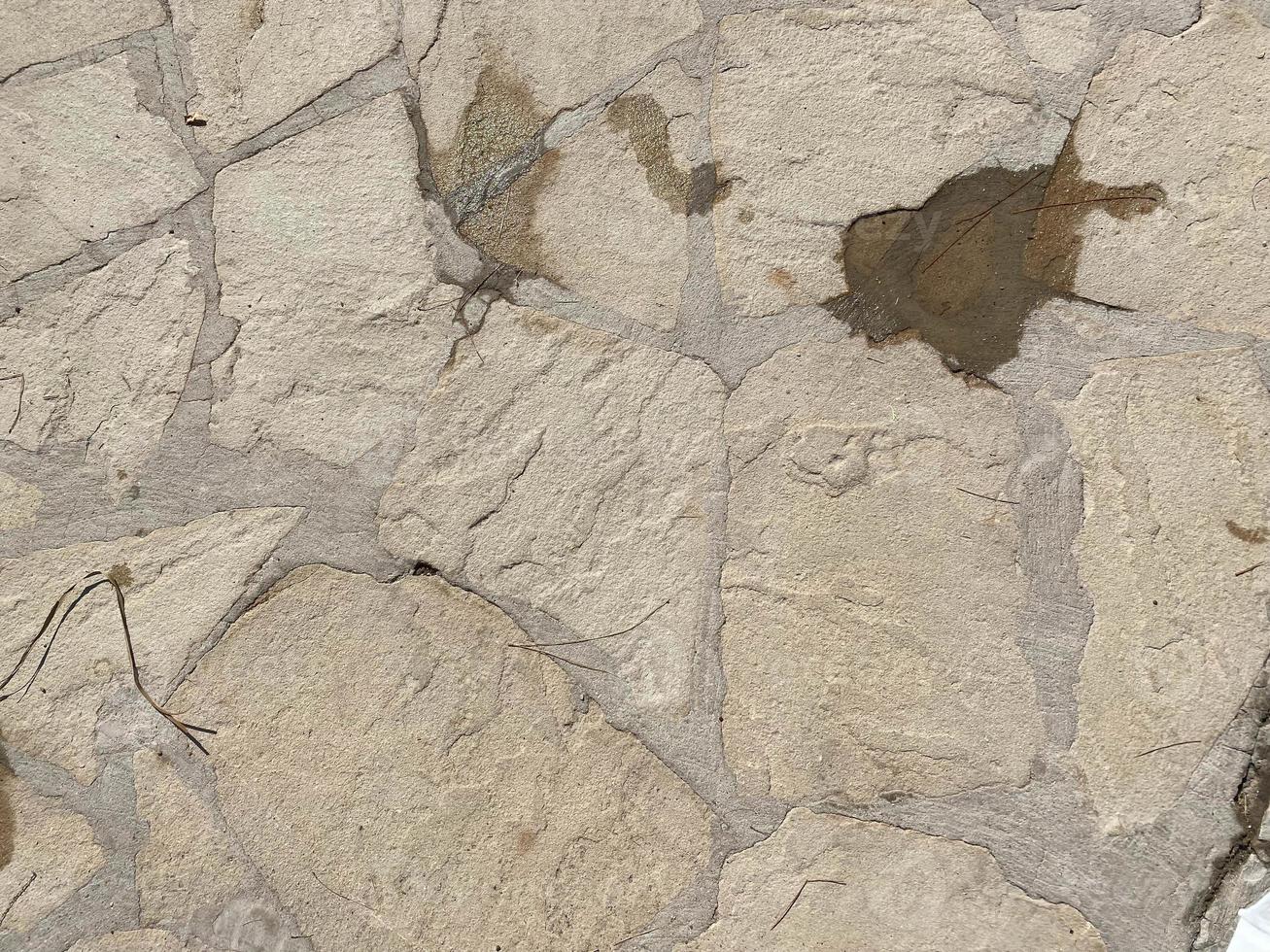 Texture of old stones of various forms with seams. Close up of shabby masonry. Stone wall from uneven different ancient friable cobblestones photo