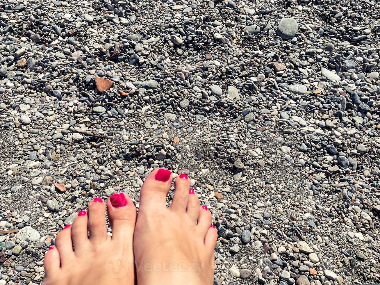 piernas de mujer joven descansando en la playa. foto