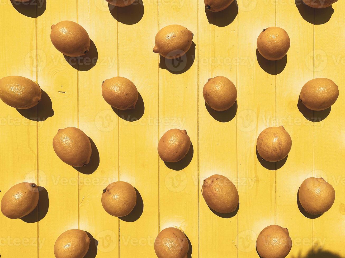 Bright beautiful juicy summer yellow pattern of sour delicious invigorating vitamin citrus lemons on a background of wooden yellow boards. The background. Texture photo