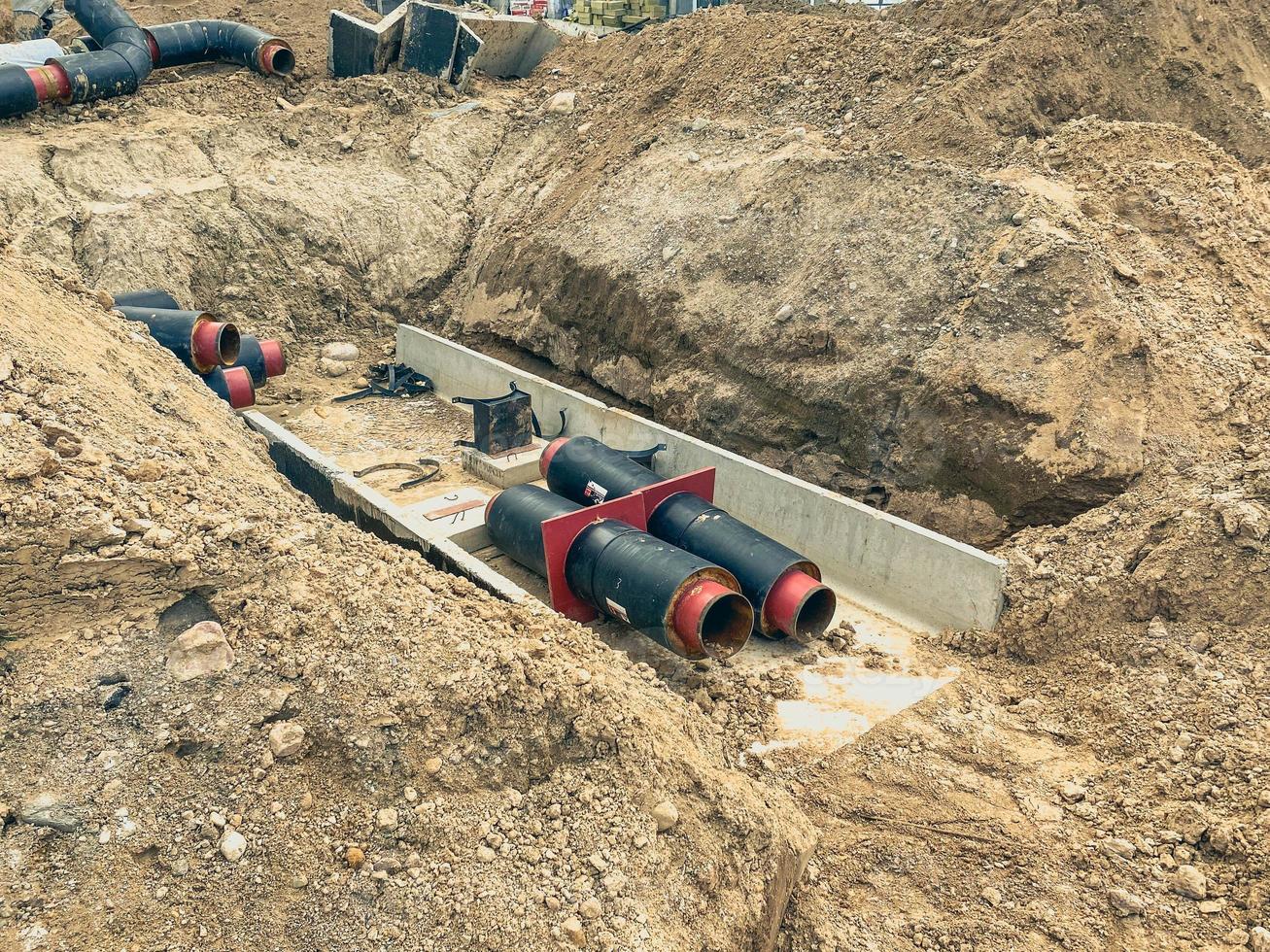 construcción de un sistema de drenaje en edificios residenciales. anchos tubos negros sobre una base gris de hormigón. tendido de alcantarillas foto