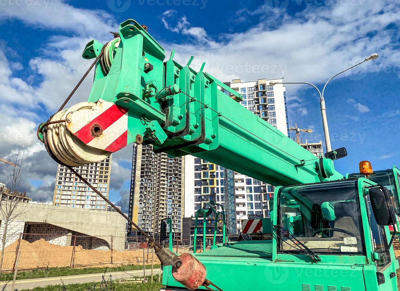 The boom-type crane moves without a load, without requiring special tracks. truck crane at the construction site of a new microdistrict, heavy automotive equipment photo