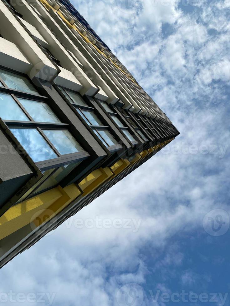 vista de esquina de abajo hacia arriba de una casa grande y alta de un edificio nuevo contra un fondo de cielo azul foto