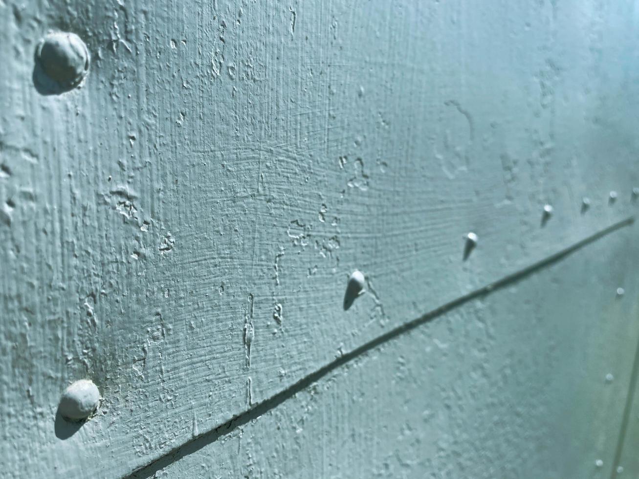 Surface texture of old scratched crumpled blue iron gritted metal painted with blue paint. The background photo