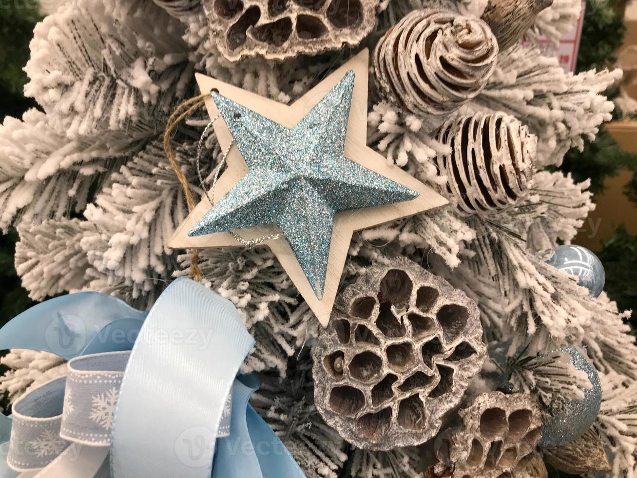 Christmas star on a fir branches on festive golden lights background, night illumination. New Year tree with decorations, magic of a holiday for background photo