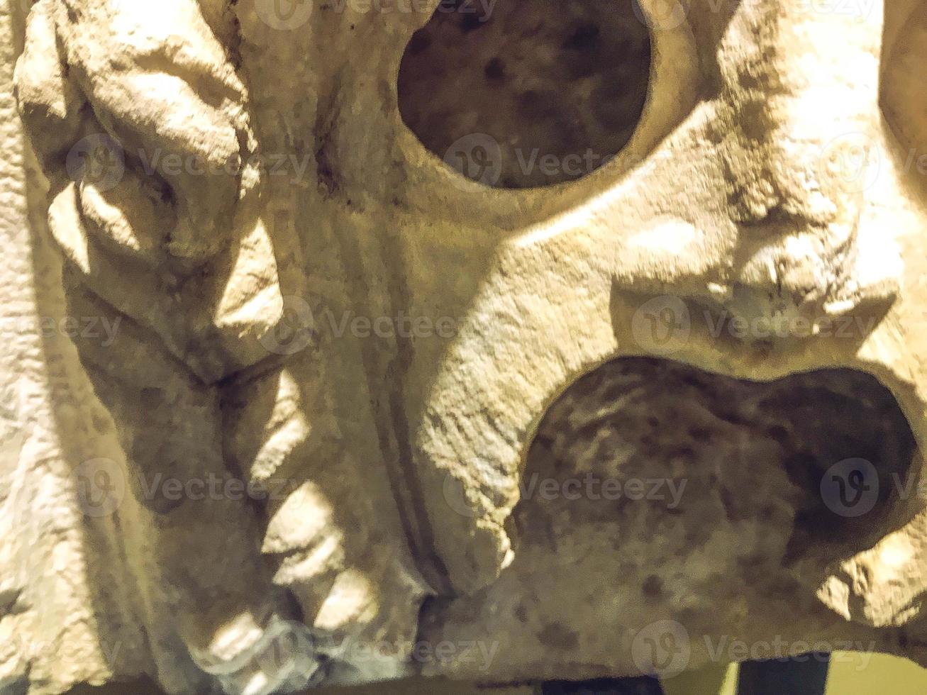 three-dimensional texture, plaster sculpture, ancient art. on the texture of scuffs, chips, cracks. creepy plaster mask with open mouth and large eye sockets photo