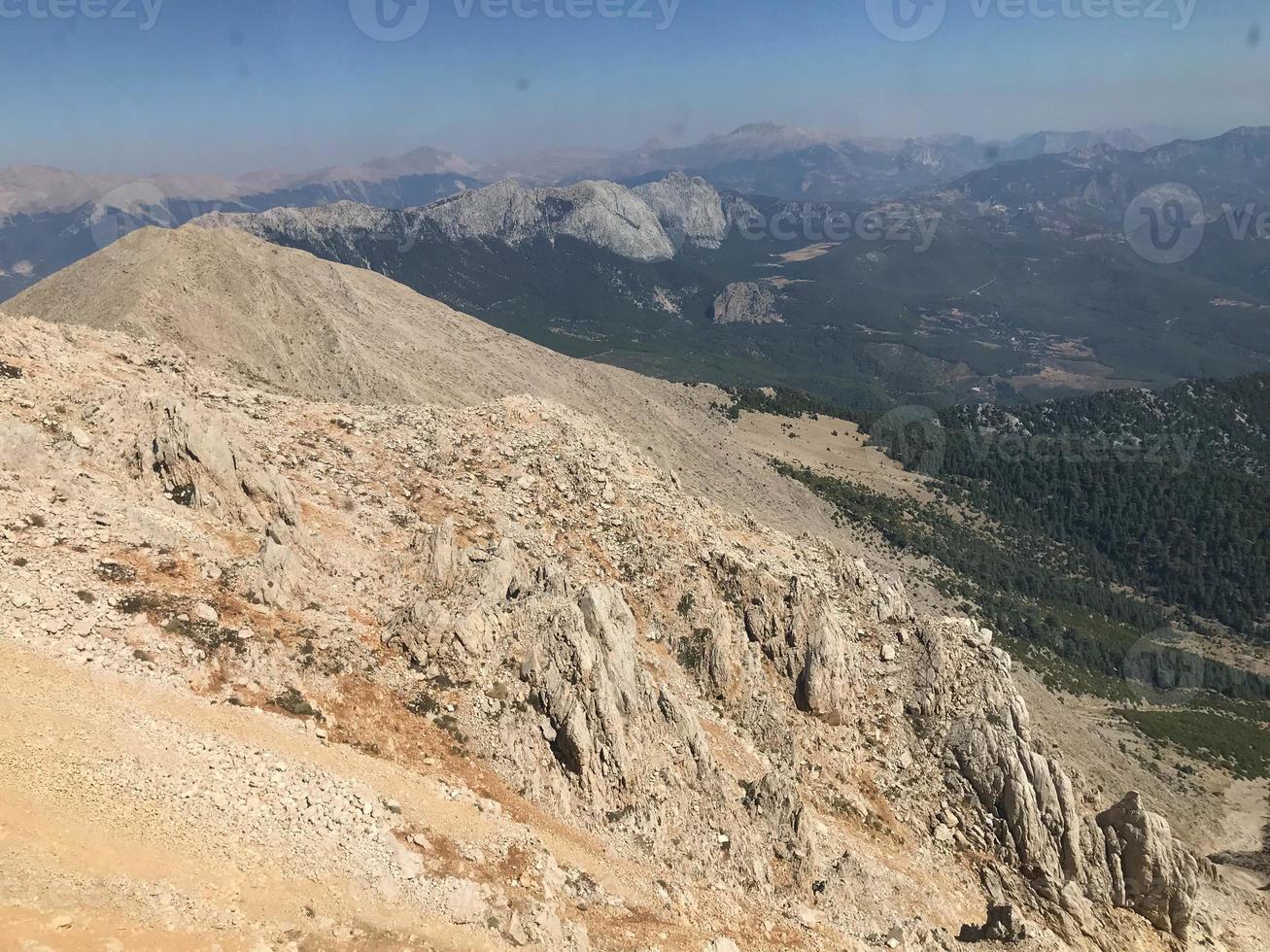 view from the mountain at sunset to the settlement in the valley of the confluence of mountain rivers photo
