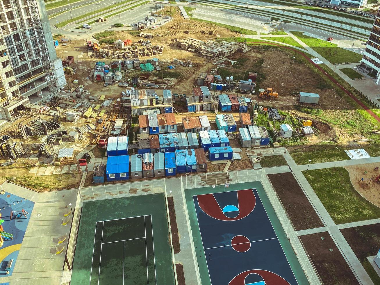 basketball court in the new neighborhood. rubberized floors for anti-slip running. ball throwing ring. next to a construction site, wagons for the life of builders photo