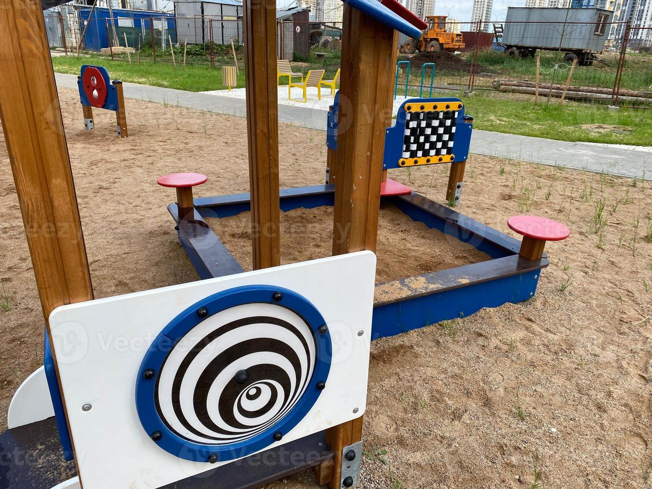 children's pink playground in the center of the residential complex. for kids there are swings, abacus, fun slides and climbing frames. playground in a new area next to tall apartment buildings photo