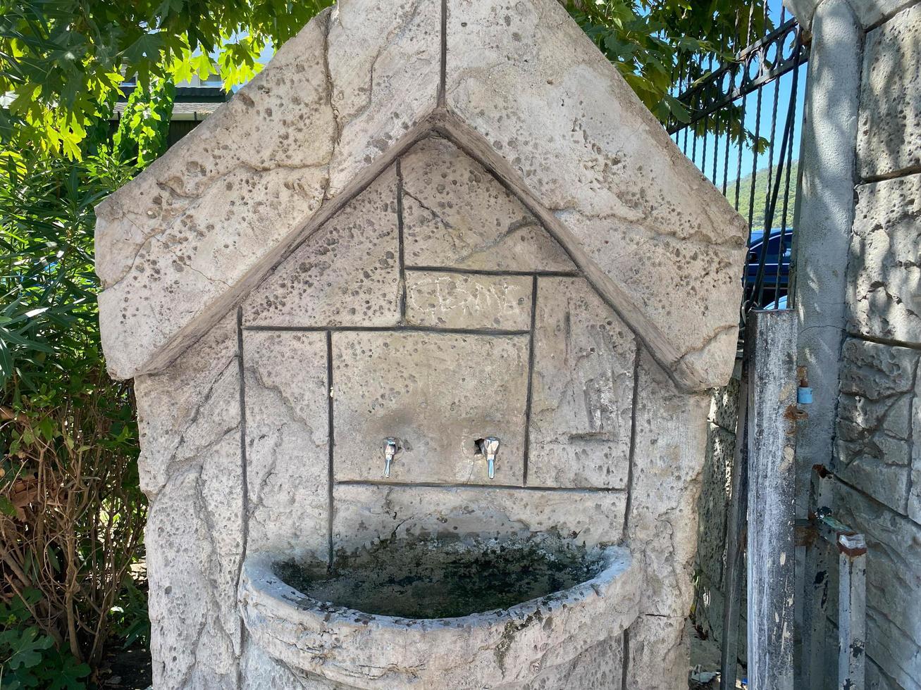 Antique street faucet drinking fountain in Italy photo