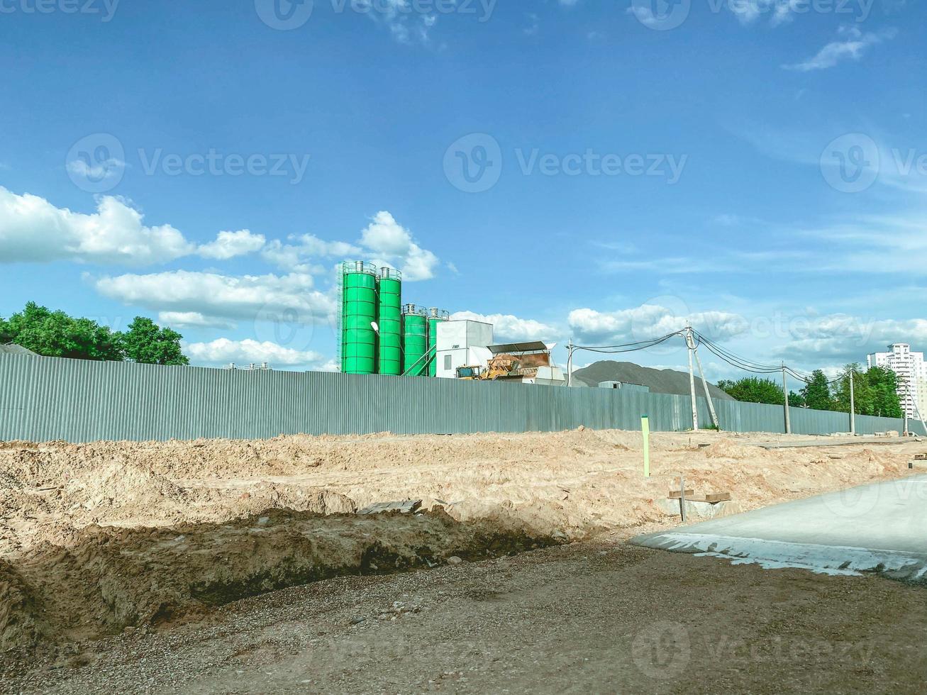 a concrete knot of bright, green color stands behind a building fence. production of concrete at the construction site. high concrete junction for construction work photo