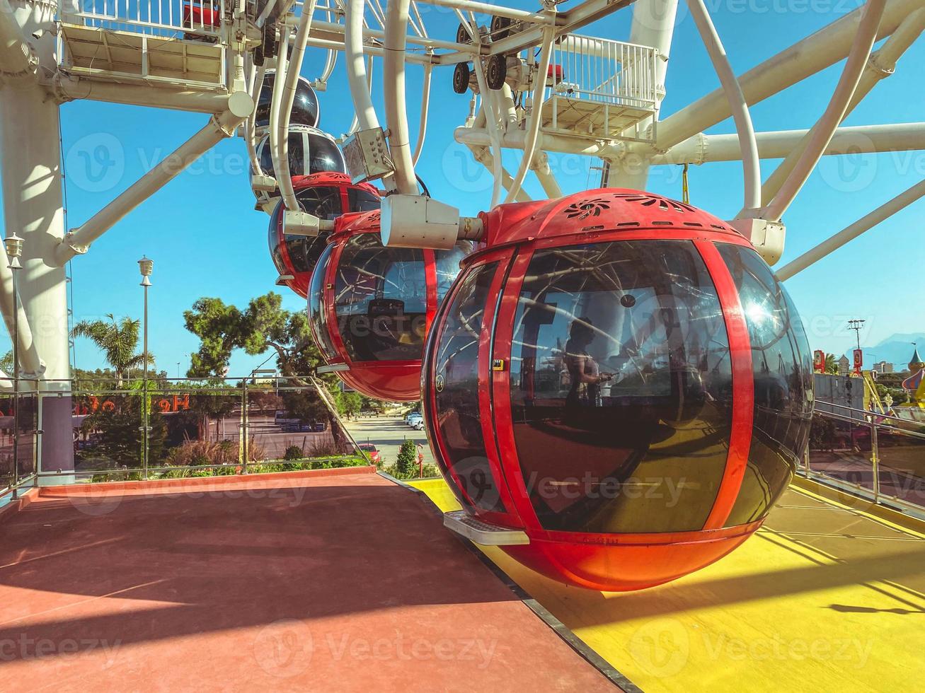 on the Ferris wheel there are large cabins for skiing tourists of red color with black, tinted windows. a place for boarding tourists in a cabin photo