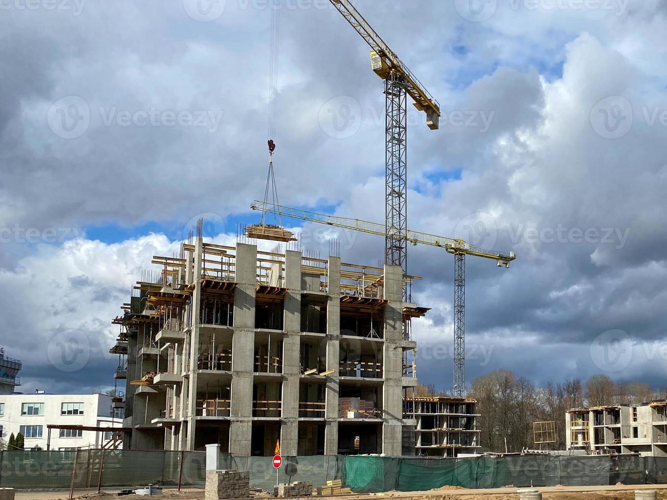 Construction of new high-rise building in the city two construction cranes in a construction site photo