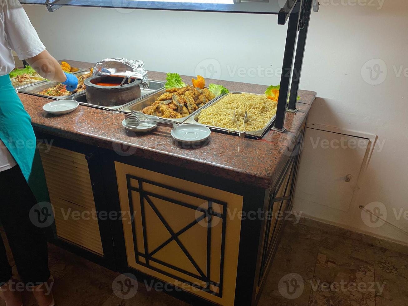 masked chef stirring goulash with vegetables, all-inclusive restaurant photo