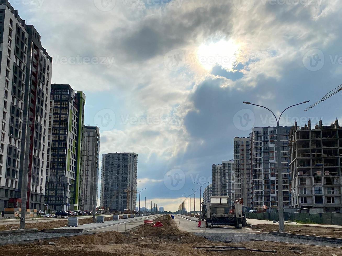 Construction of a wide high road in a new microdistrict of a large city with high-rise buildings and dense settlement photo