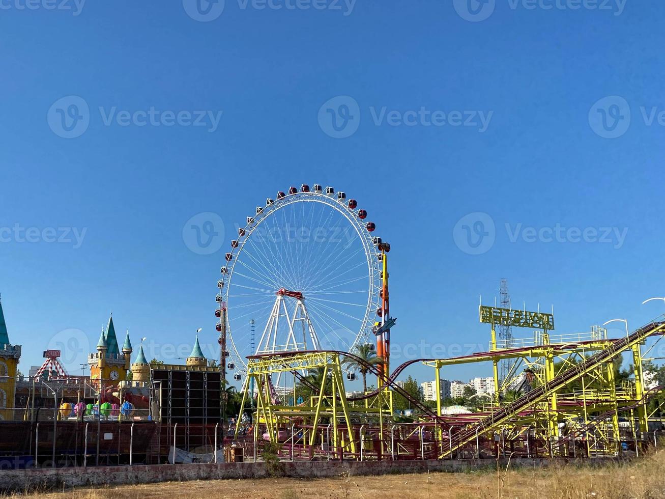 Ferris wheel and roller coaster rides at pier pacific park at sunset with people riding attractions photo