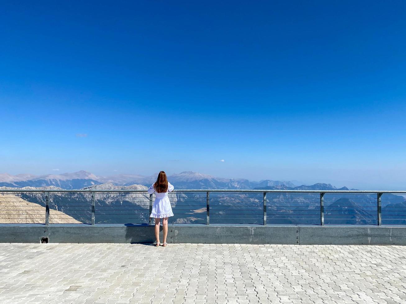 Woman at the observation deck in a deep canyon - breathtaking views of nature in the mountains photo