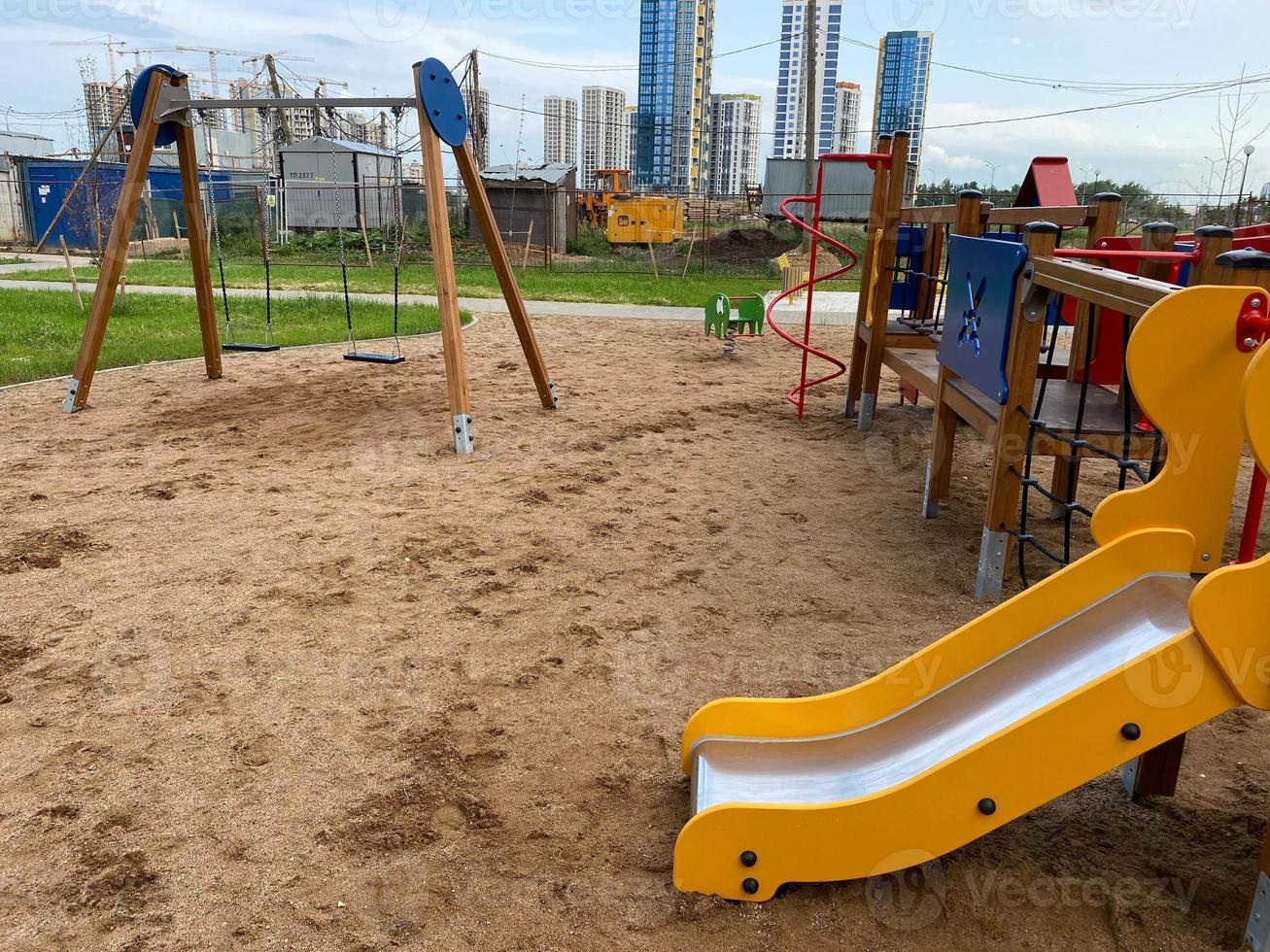 Children's new modern sports playground with various activities, games, swings, slides, carousels and sandpits with a rope town in the open-air courtyard photo