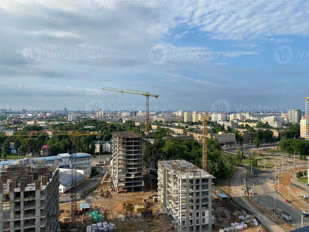 A view from a height of a large modern construction site of tall large houses and multi-storey buildings. A construction site for the development of a new microdistrict in a big city photo