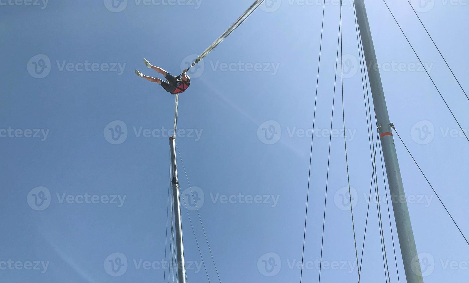 jumping on a high mountain. outdoor activities in a hot country, rope jumping, trampoline on the edge of the mountains. a large structure, a catapult for launching people into the sky photo