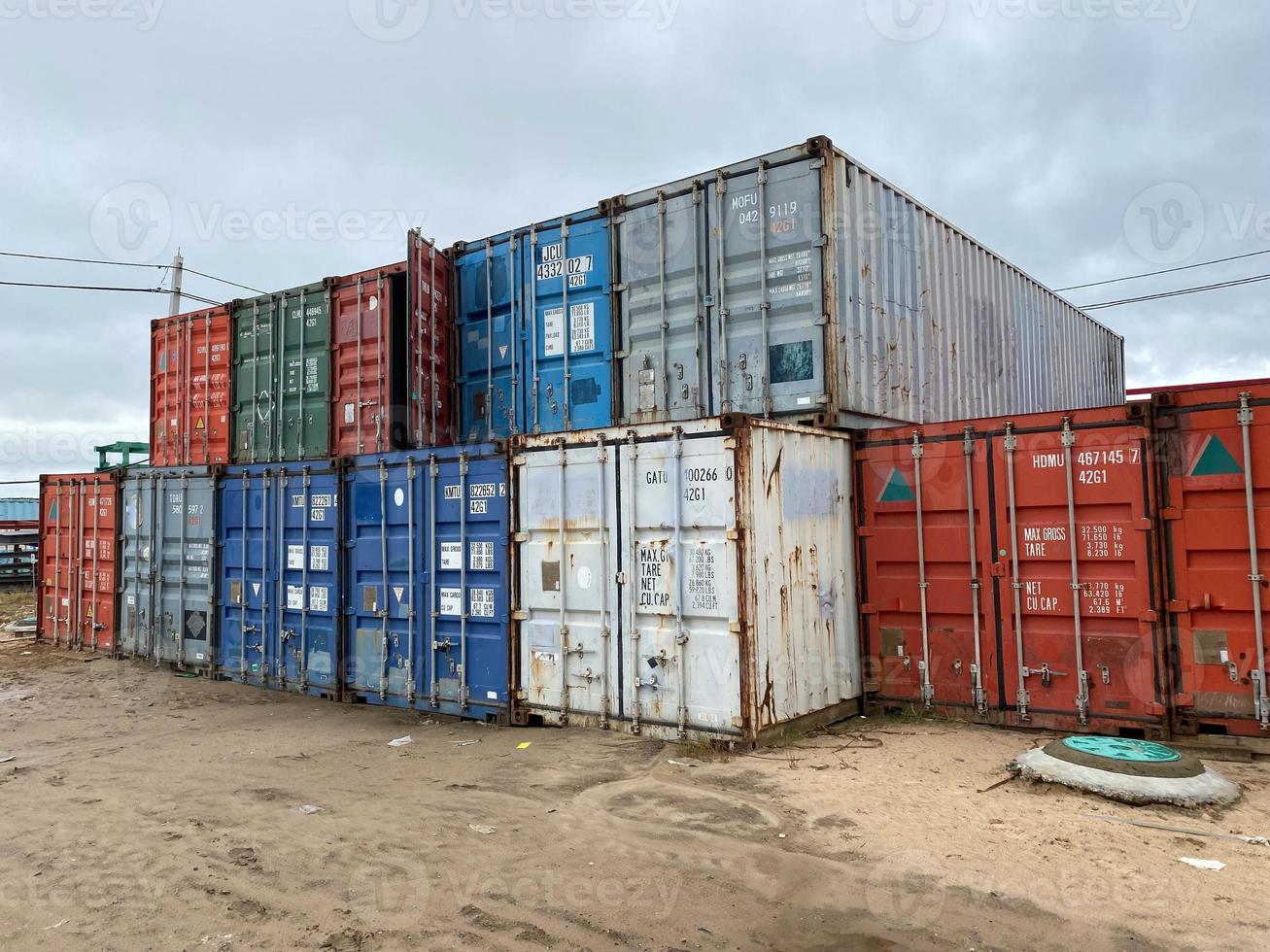 Multi-colored iron industrial sea containers for international transportation of goods according to the logistic rules of Incoterms 2010 DAP and DDP photo