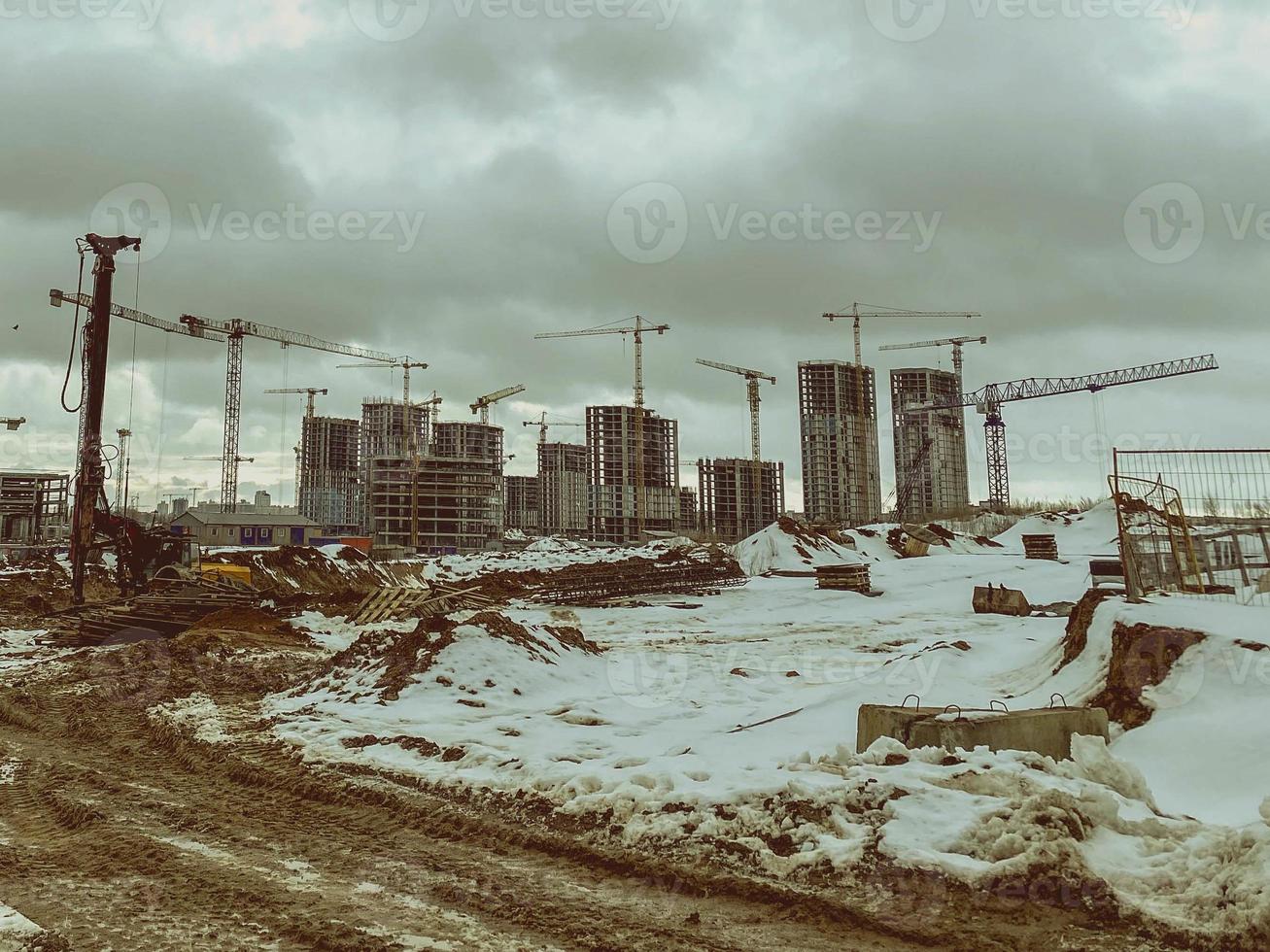 construction of houses, a shopping center from concrete blocks in the city. construction of a new residential quarter in winter. equipment is working on the site, traces of large tires photo