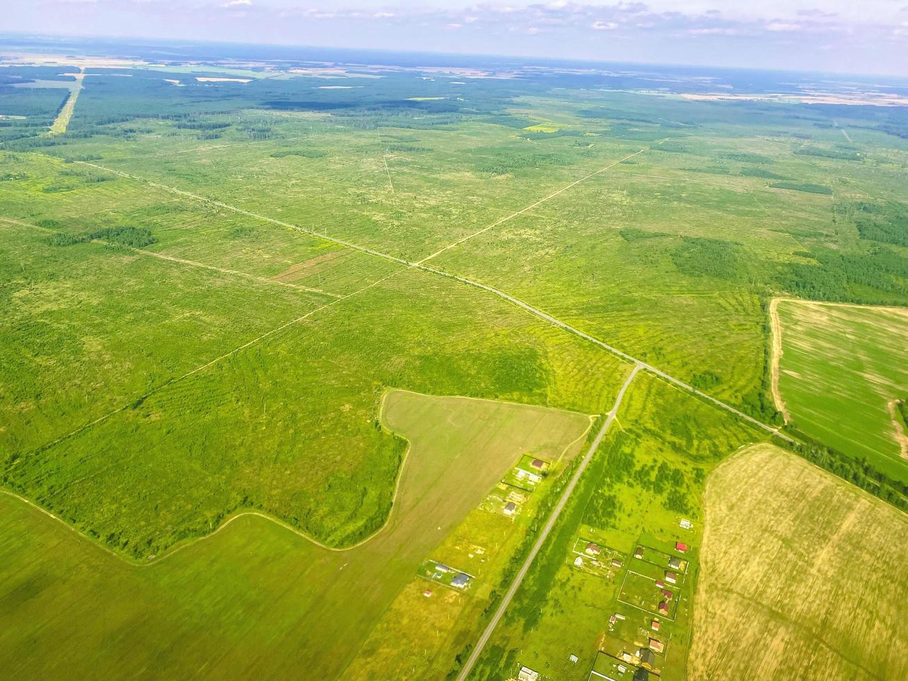 travel through the sky to another country. the plane rises in the sky. view of the green, clean fields from a height. near the seas and oceans of blue color photo