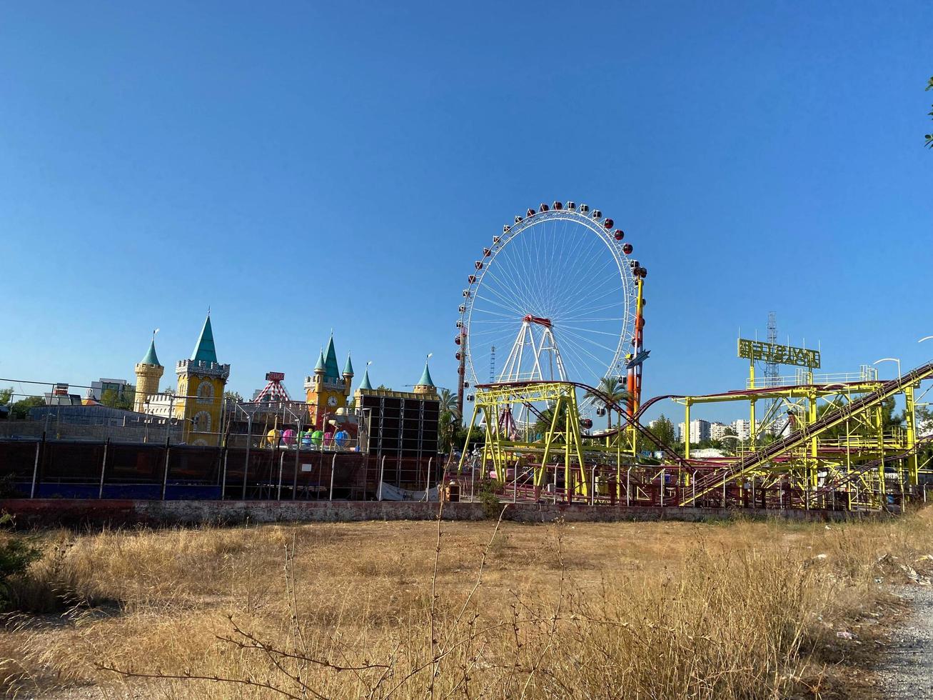 Fair carnival rides and tent top against blue sky photo