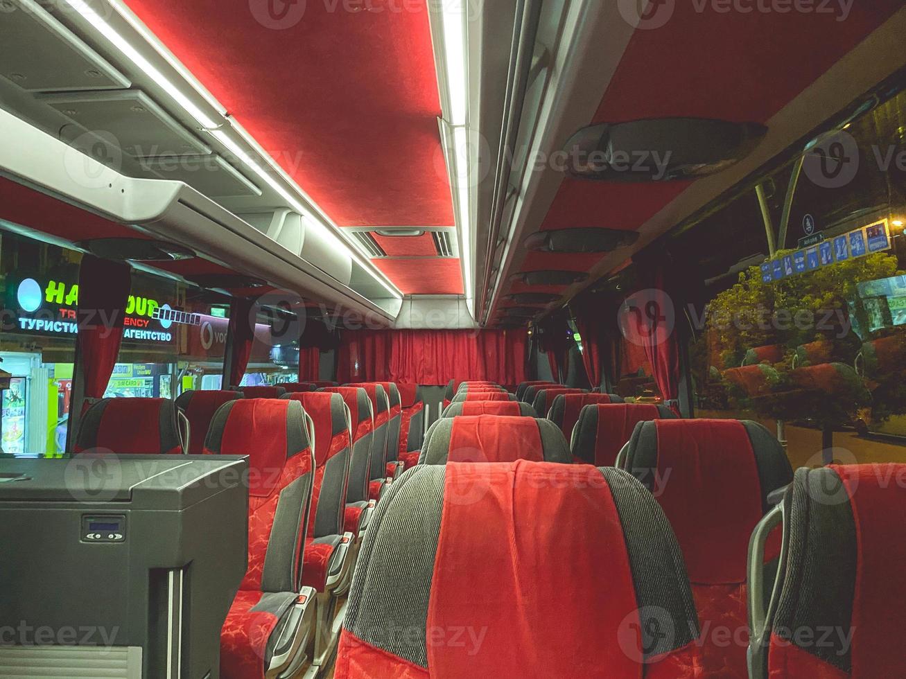cómodo y caro autobús con suaves asientos de terciopelo rojo. caro interior del autobús con muchos lugares para turistas. viajar por tierra foto