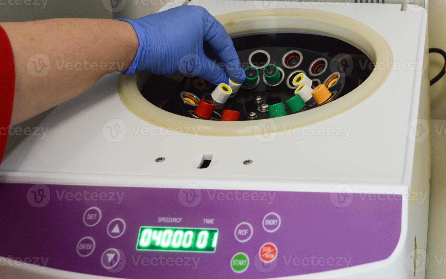 Covid-19. A worker in medical gloves puts a sample in a laboratory centrifuge. Copy space. Concept of scientific and medical research of the coronavirus vaccine photo