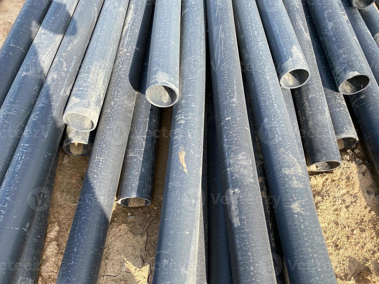 Plastic main pipes. A heap of polyethylene pipes for a water supply system. Objects for laying of city communications and the sewerage. The concept of laying urban communications photo