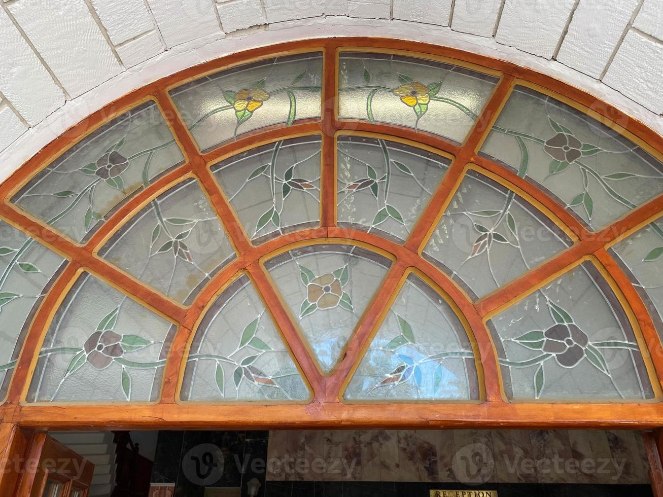 Image of a multicolored stained glass window with irregular block pattern in a hue of blue, square format photo