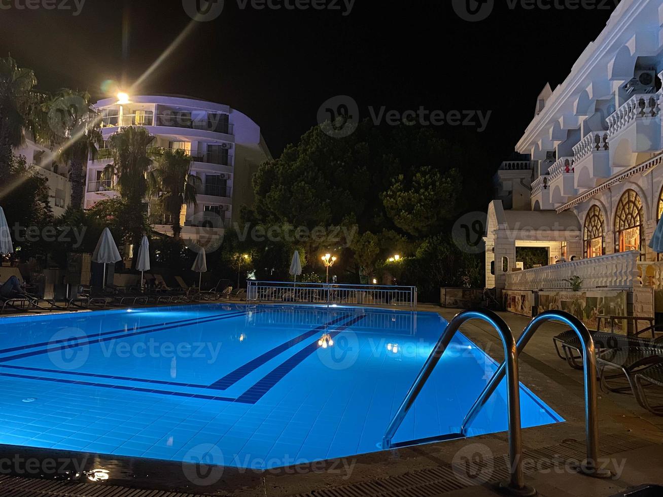 hotel de lujo con piscina por la noche foto
