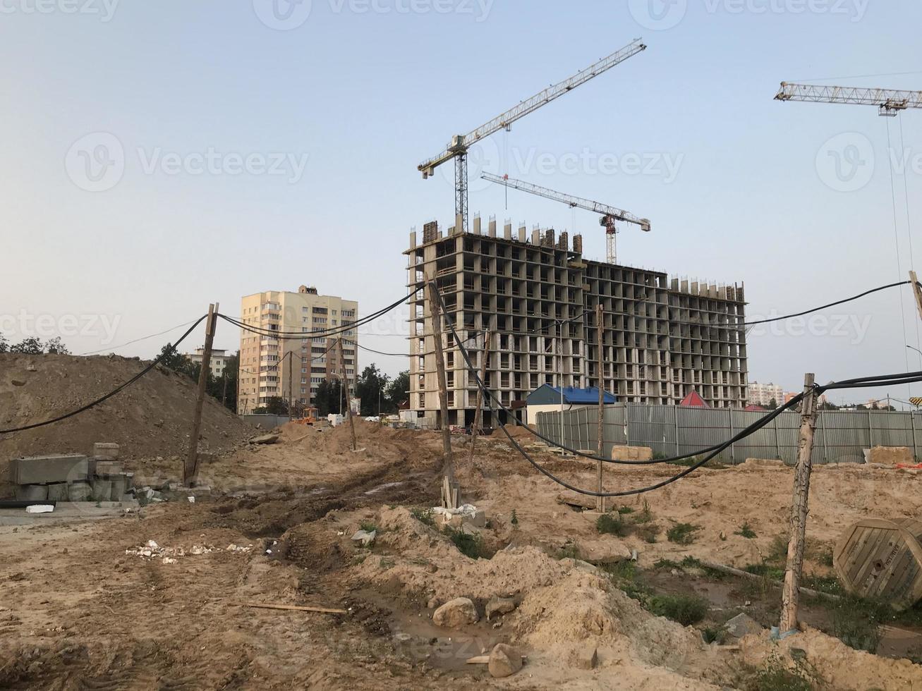 construction of a new microdistrict in the city center. tall concrete block houses. glass buildings, modern home for families and couples photo