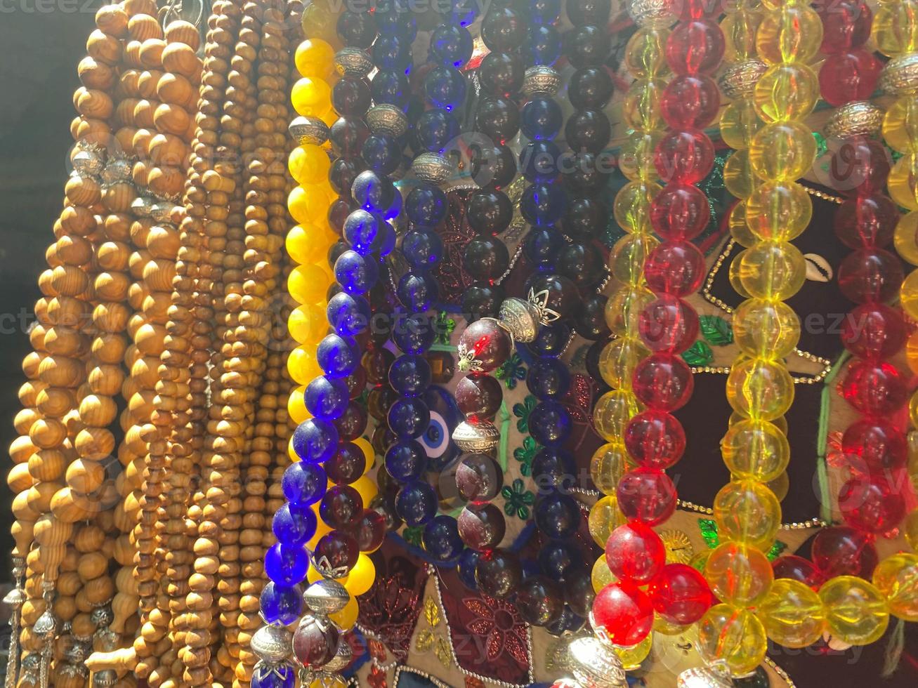 Bright background of handmade strands of colorful beads at outdoor crafts market photo