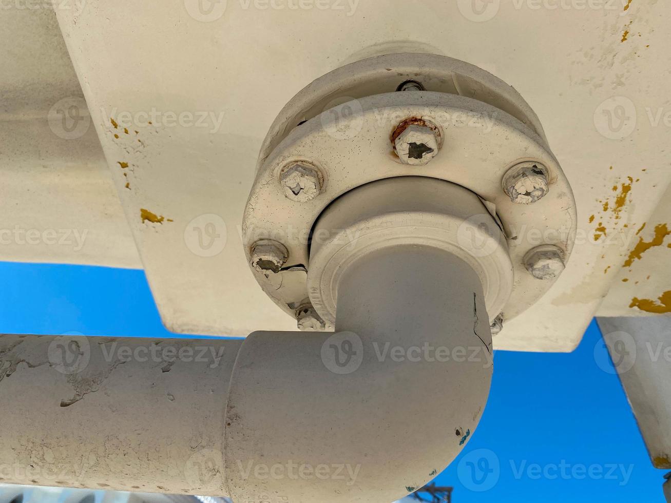 close-up view of the flange with bolts of a heavy metal joint on a pipe that transports liquid to an industrial plant photo