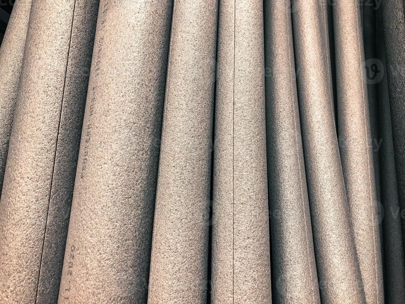 white foam rubber round shape, volumetric foam rubber for construction work. goods in a hardware store for insulation and insulation of pipes. foam pipe with insulation seam photo
