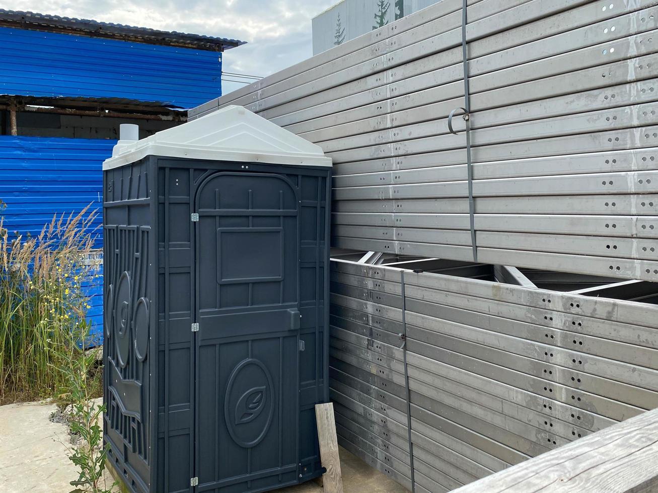 Plastic lightweight portable black temporary dry closet at the construction site for builders or for public events photo