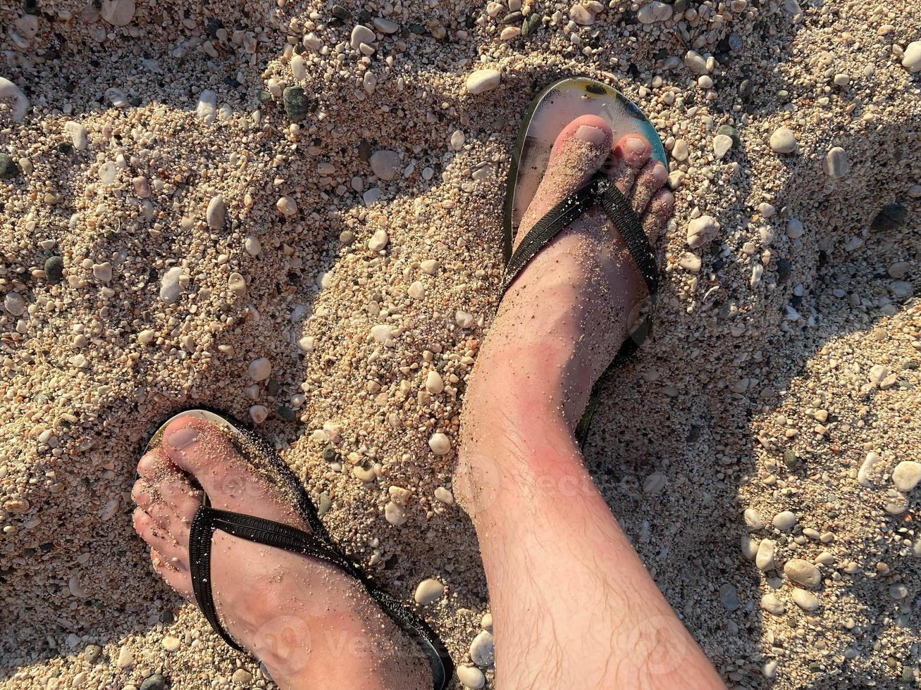 Top view close up of man wearing blue flip flops walking along tropical exotic ocean beach photo