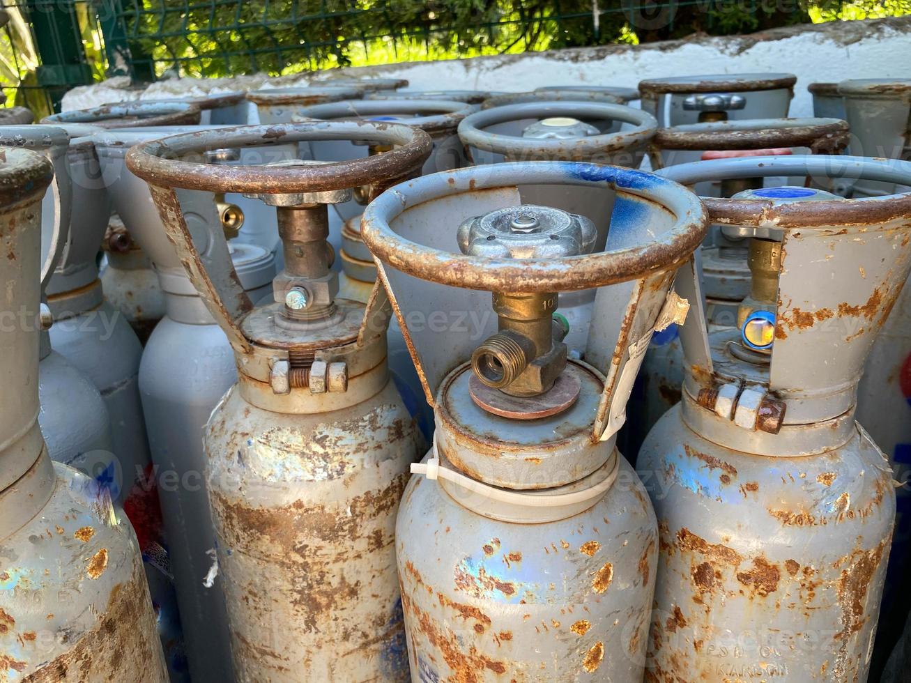 muchos cilindros de gas portátiles antiguos frente a la tienda de gas para el servicio foto