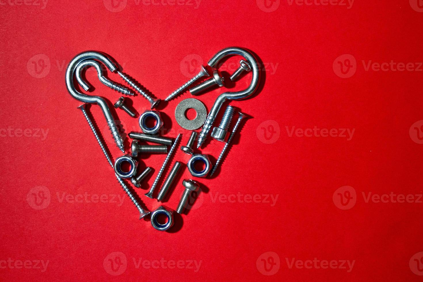 Bolts, nuts, hex and other construction tools laid out in a heart shape, Valentines day postcard, banner, wallpaper, cover design, holiday concept. Flat lay, top view, free place for text, copyspace photo