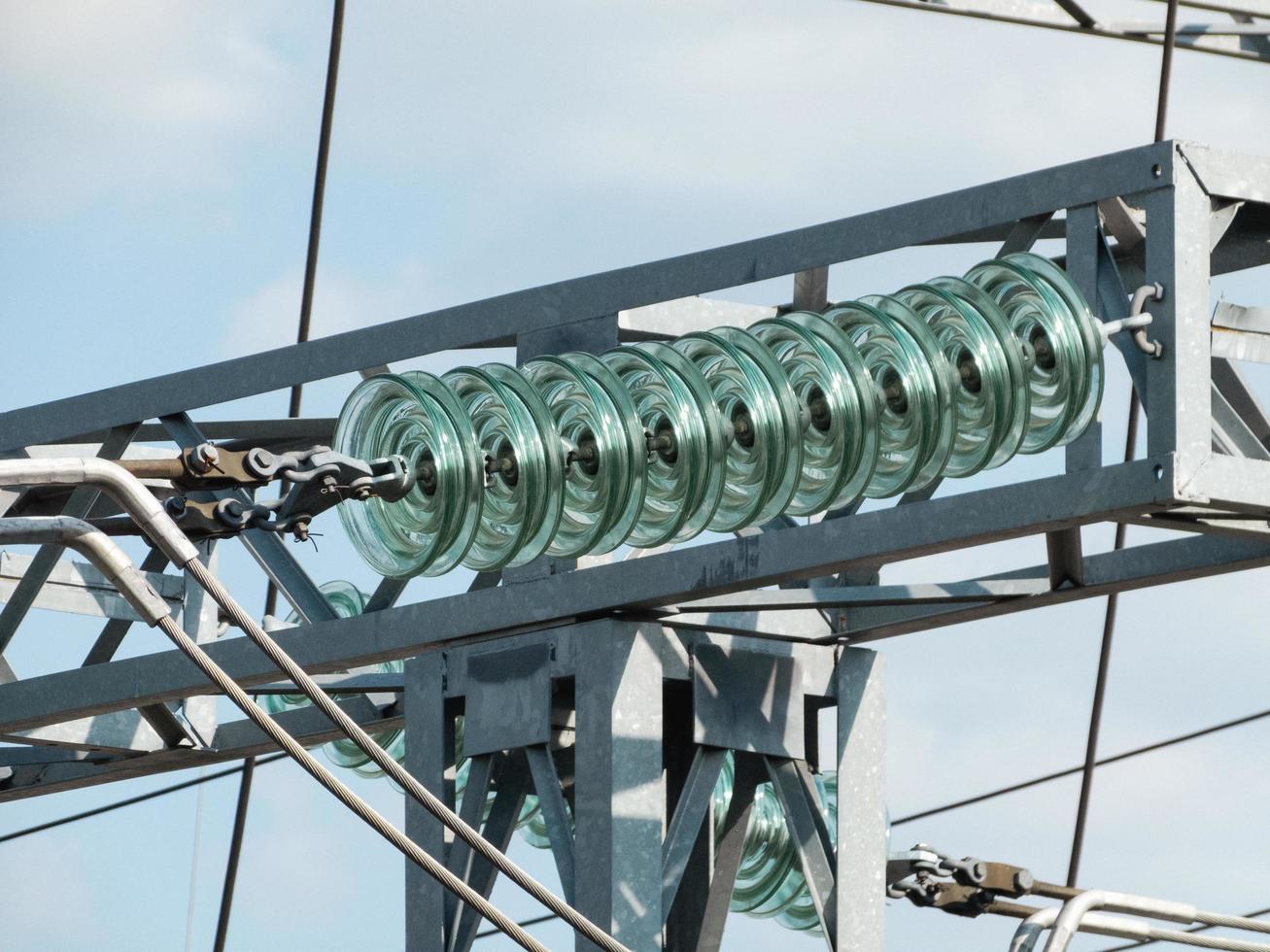 Glass linear isolator on high-voltage power tower. photo