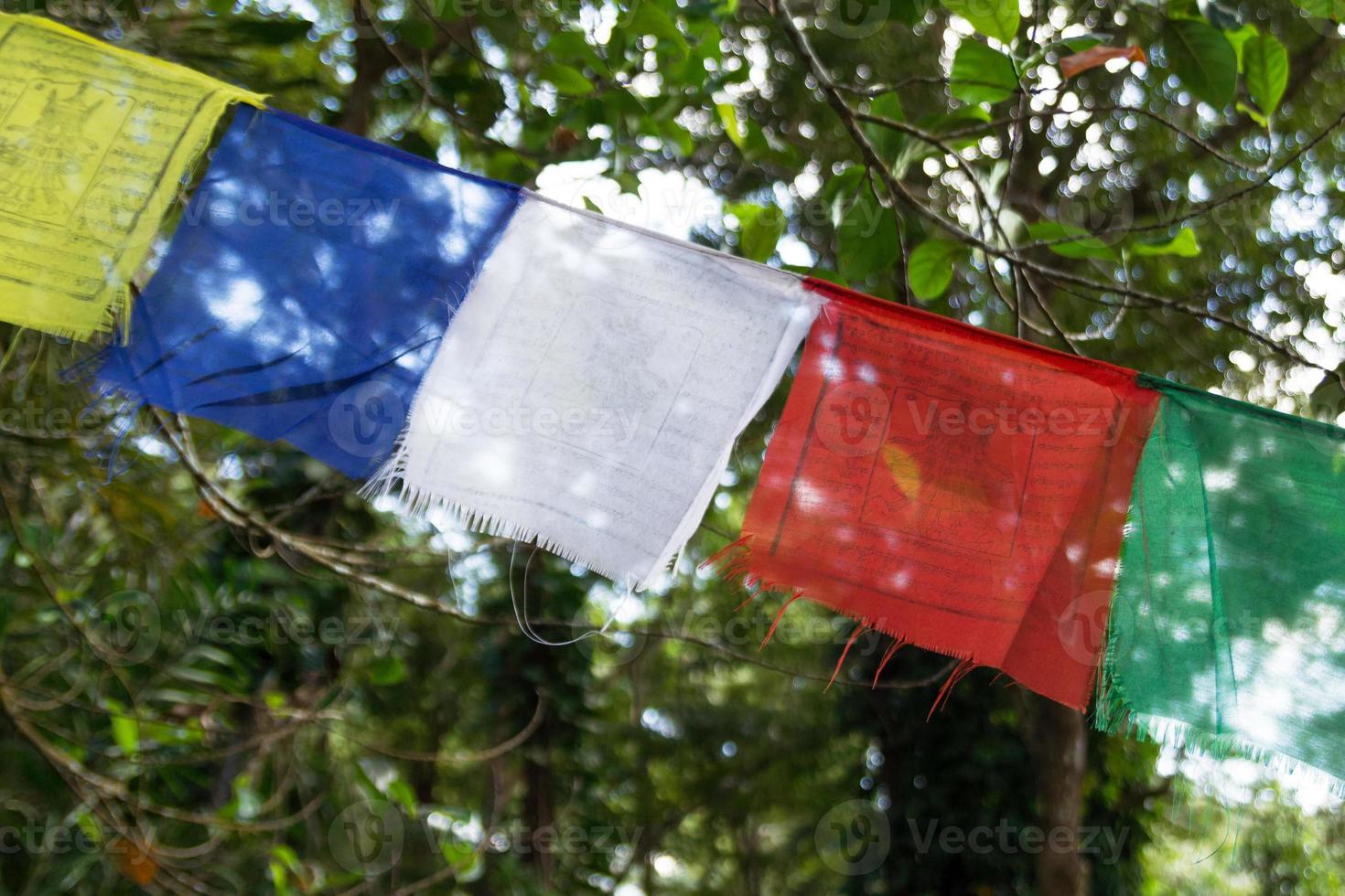 View on a colorful flags on a background of trees on a sunny day. Chiang Mai province, Doi Suthep, Thailand. photo