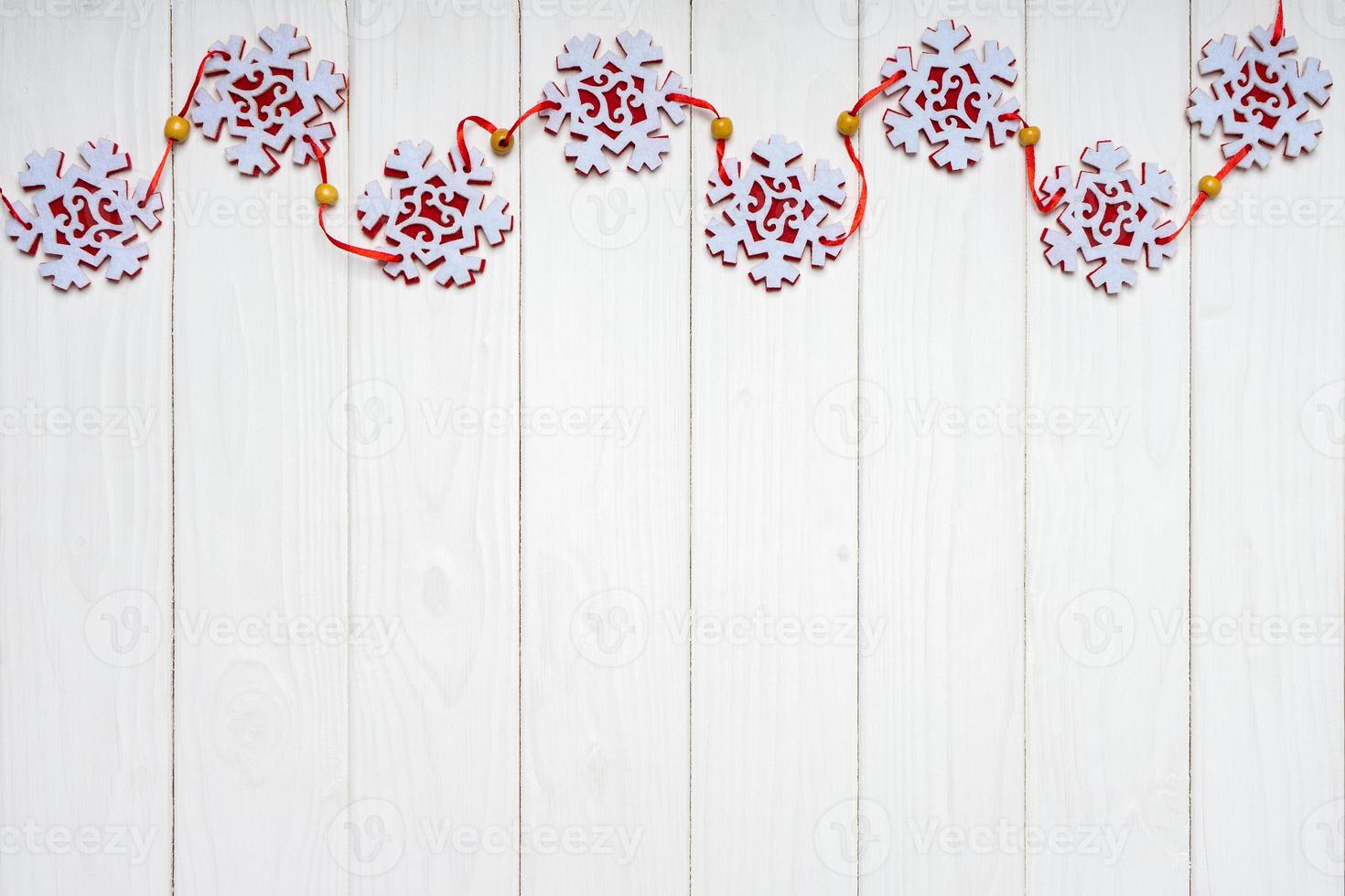 Christmas background with red felt snowflakes garland. Top view, flat lay with copy space photo