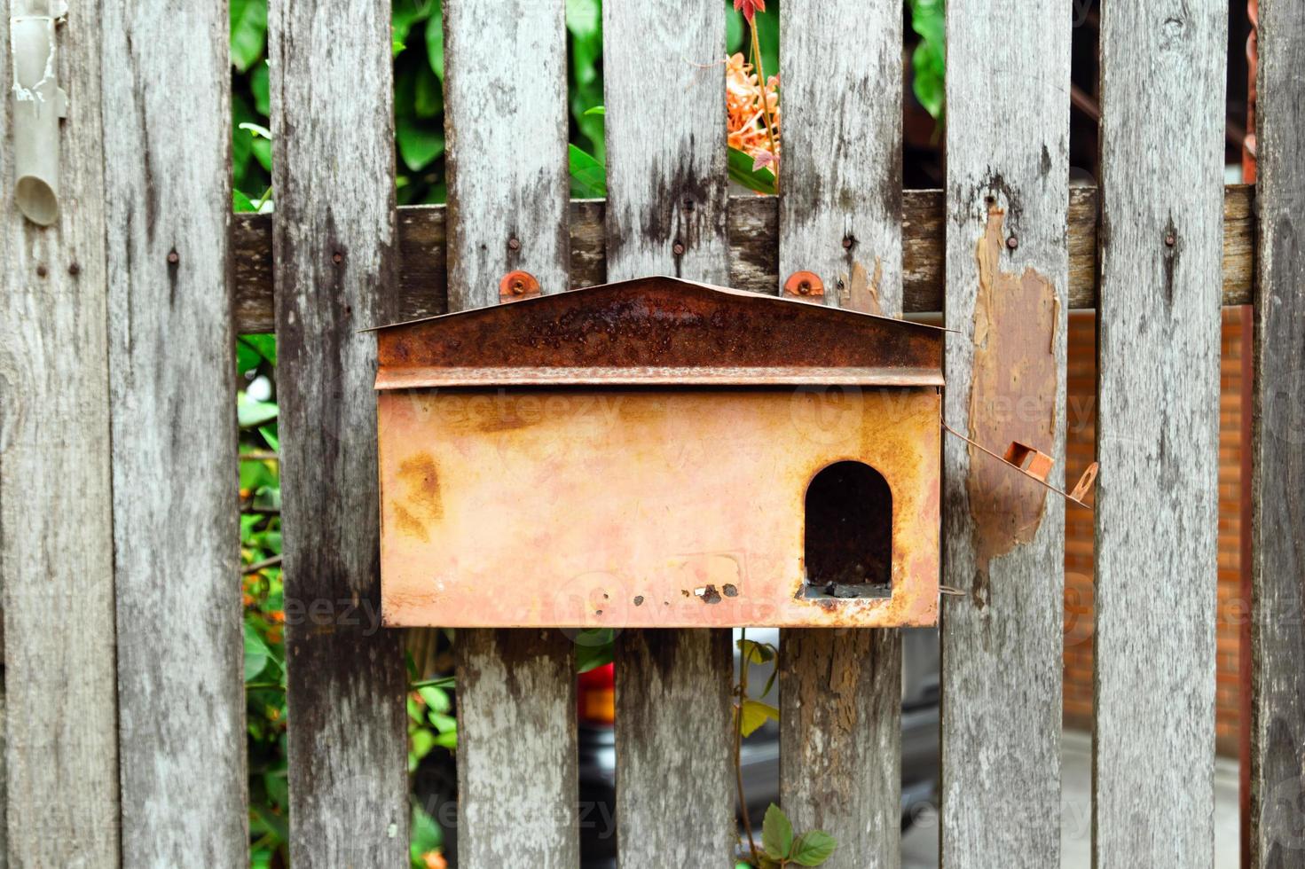 Old shabby postbox on a wooden wall. Chiang Mai, Thailand. photo