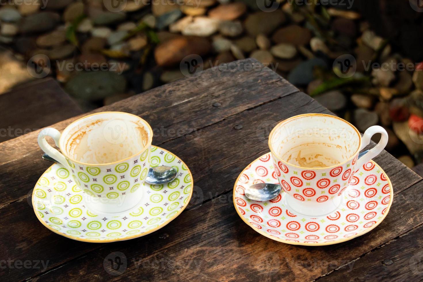 Two empty colorful cups after drinking coffee on a wooden table in a cafe. photo