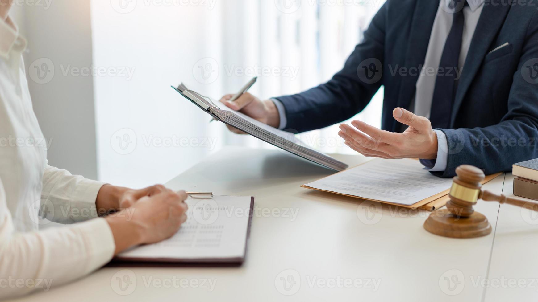 law concept The attorney holding the paper and having a law inspection about the contract of the company that the offer with his helper photo