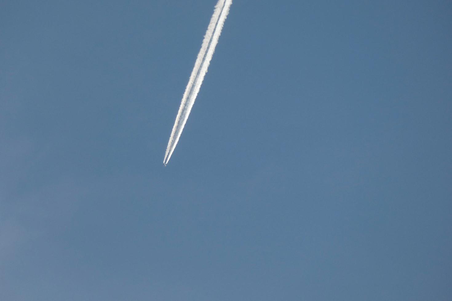 white wake of an airplane under the blue sky photo